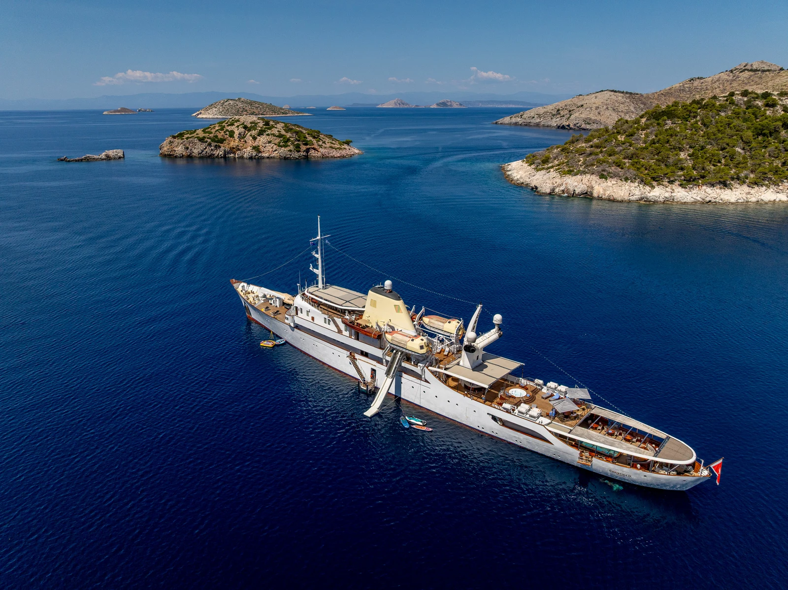 Yacht at anchor among rocky islands