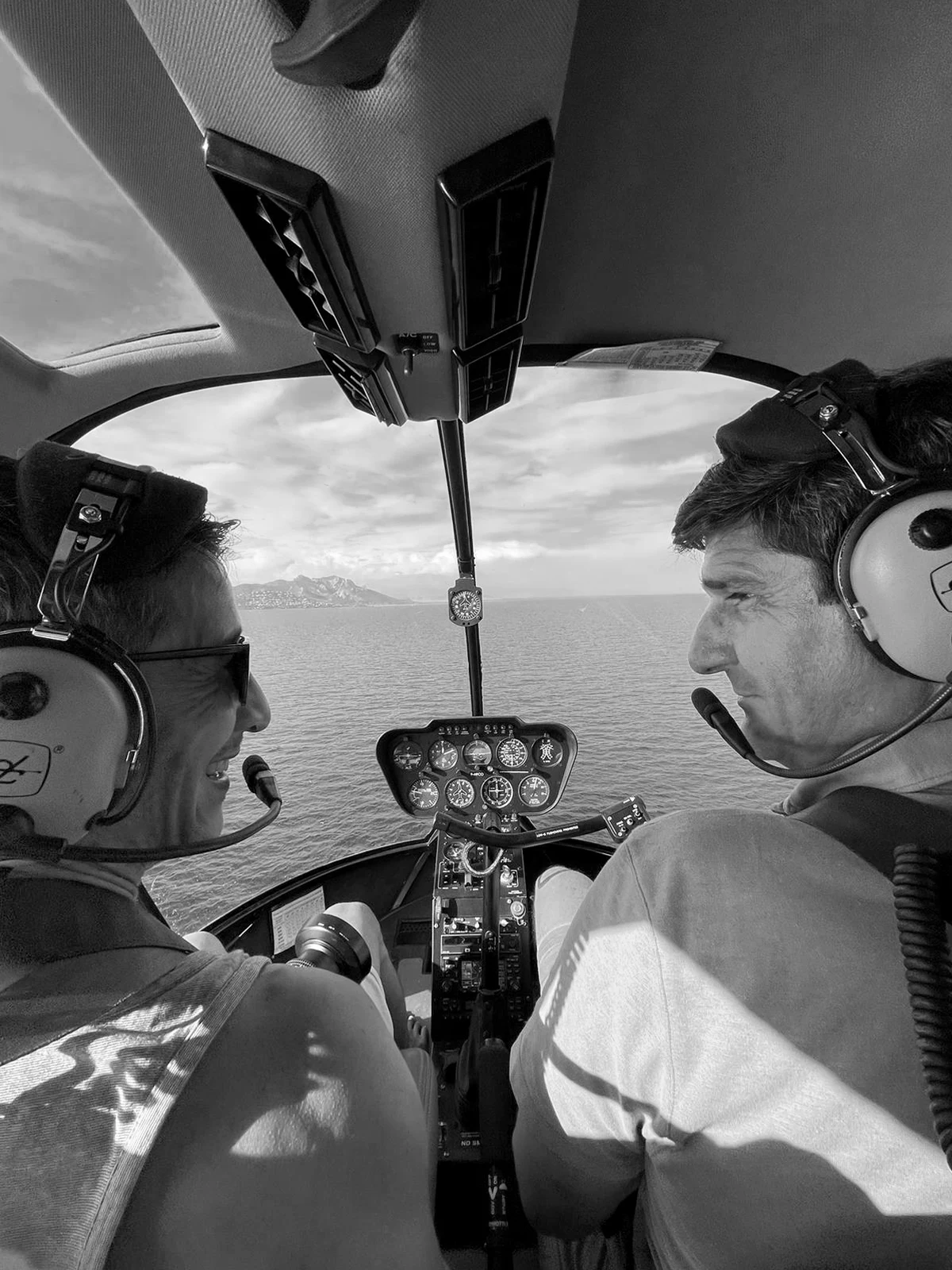 Photographer and pilot aboard a helicopter above the sea